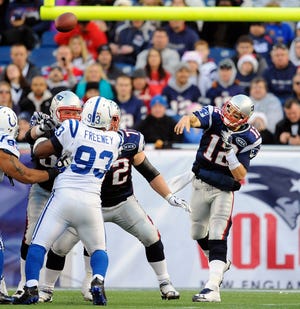 Patriots quarterback Tom Brady (12) throws a pass against the Colts as defensive end Dwight Freeney (93) is kept at bay by the offensive line.