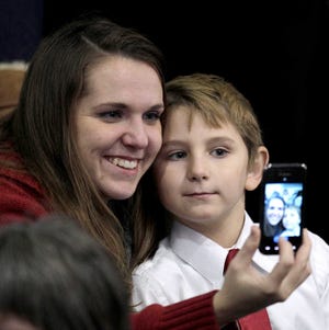Audience members take a photo as they wait for the arrival of President Obama Tuesday at Osawatomie High School.