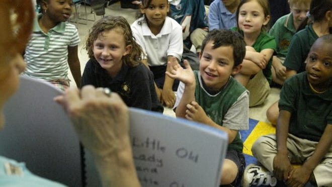File photo of book being read to kindergarten students in 2008 that include (L-R, front row) Catherine Cela (in navy polo), Jordan Anderson (with hand raised), and Fredenks Saint Fleur (far right in green polo) at Chancellor Charter School in Lantana.