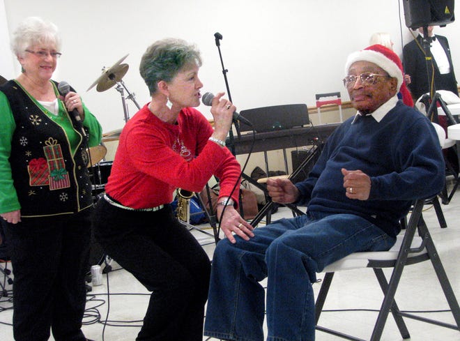 Jimmy Binkley plays along as a ponderous St. Nick mulling gift requests from Phyllis Draper, singing "Santa Baby" Wednesday at American Legion Post 979 in Bartonville. Draper and Gladys Ivery, left, two-thirds of the local group 9to5, were part of Binkley's 128th Annual Christmas Party for Seniors.