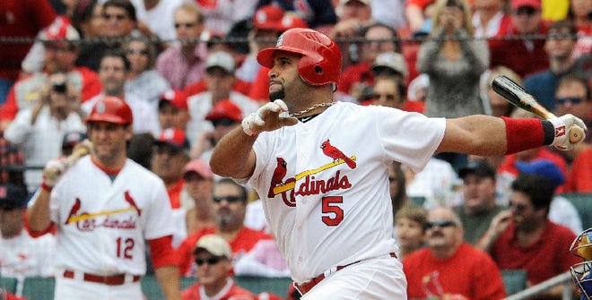 This Sept. 25, 2011 file photo shows St. Louis Cardinals' Albert Pujols (5) batting against the Chicago Cubs as Lance Berkman (12) waits on deck in the final regular season home baseball game, in St. Louis. A person familiar with the negotiations says that Pujols has agreed to a 10-year contract with the Los Angeles Angels. The person spoke on condition of anonymity Thursday, Dec. 8, 2011, because the deal had not been announced.