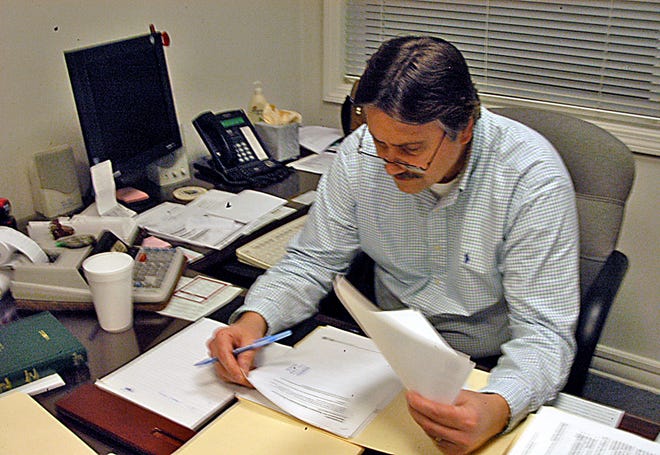 Paul Slivinski, executive director of Taunton's Contributory Retirement System, is looks over documents in his Dean Street office.