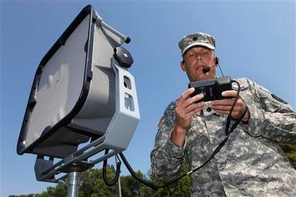In this photo taken Sept. 14, 2011, Lt. Col. Jeffrey Bevington, requirements officer with the Joint Non-Lethal Weapons Directorate, demonstrates one of the military's latest voice projection system and instant translation technologies, that can project a human voice a mile away and instantly translate from English to another language, at the Marine Base in Quantico Va.