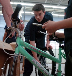 Weymouth High School automotive students, including Matthew Healey, center, assemble bicycles at school, Tuesday, Dec. 6, 2011. The bikes, given by an anonymous donor, will go to the charity My Brother's Keeper for distribution during the holiday season.

photo: Amelia Kunhardt/The Patriot Ledger