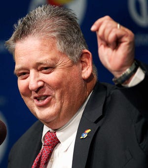 New Kansas coach Charlie Weis talks with reporters after his was introduced during an NCAA college football news conference in Lawrence, Kan., Friday, Dec. 9, 2011. (AP Photo/Orlin Wagner)