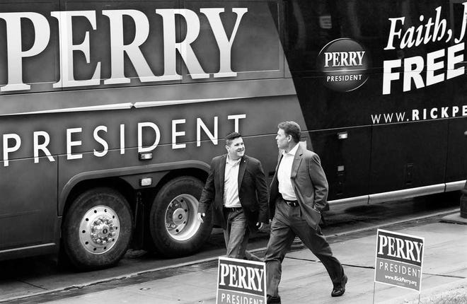 Republican presidential candidate Texas Gov. Rick Perry, right, walks with former Marine officer Dan Moran during a campaign stop at Bayliss Park Hall on Wednesday in Council Bluffs, Iowa.