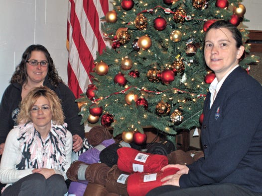 Captain Amy Voss of The Salvation Army (at right) accepted blankets donated by Kate Hoornstra, circulation manager, and Tracy Coullard, special promotions coordinator, on behalf of The Evening News on Thursday. Each year, some of the proceeds the newspaper receives from local advertising sponsors on the Project Christmas Warmth:?Spreading Holiday Warmth One Blanket At A Time pages purchase blankets to be donated to needy families through The Salvation Army.