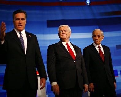 Newt Gingrich between Mitt Romney, left, and Representative Ron Paul at the debate on Thursday in Sioux City, Iowa.