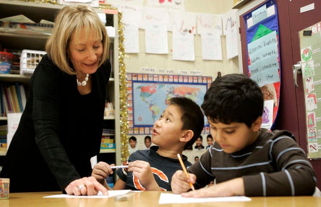 English as a second language teacher Fran Frano (from left) works with Telmuun Batzul, 7, and Aziz Thabet, 7, Thursday, Dec. 15, 2011, at Johnson Elementary School in Rockford. Batzul is from Mongolia and Thabet is from Yemen.