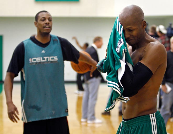 Boston Celtics guard Ray Allen wipes down his face while practicing with forward Paul Pierce during NBA basketball training camp in Waltham, Mass., Friday Dec. 9, 2011. (AP Photo/Charles Krupa)