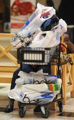 In this Nov. 25 file photo, a shopper takes a rest with purchases at Northpark Mall in Ridgeland, Miss. The U.S. economy is ending 2011 on a roll. Growth in the fourth quarter likely accelerated to the fastest pace since mid-2010, and the job market appears to be strengthening.