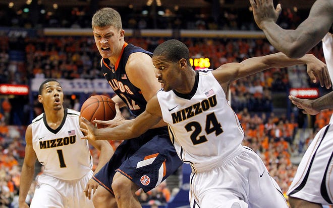 Illinois' Meyers Leonard, center, heads to the basket past Missouri's Phil Pressey, left, and Missouri's Kim English, right, during the first half of an NCAA college basketball game Thursday, Dec. 22, 2011, in St. Louis. (AP Photo/Jeff Roberson)