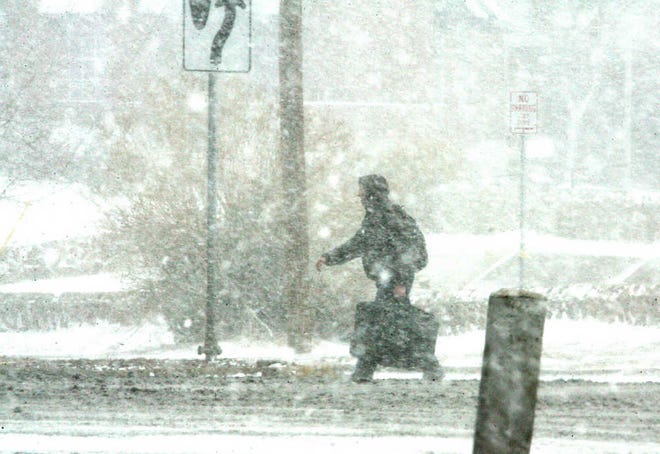 A person walks along North Mesa during a snowstorm Friday in western El Paso. The eastbound lanes of North Mesa were closed due to treacherous driving conditions. Some lanes on Interstate 10 have also been closed at various parts of the city.