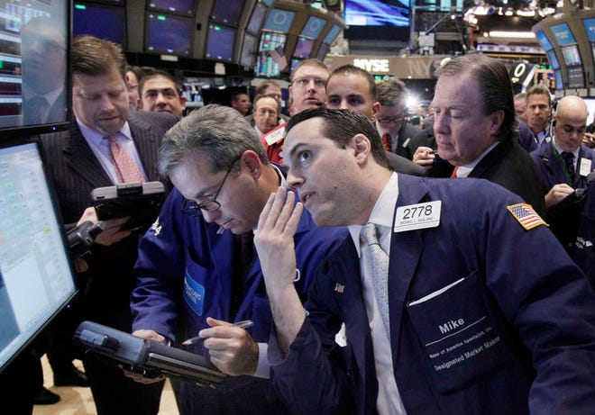 Specialist Michael Gagliano, foreground right, works at a post on the floor of the New York Stock Exchange on Dec. 9.
