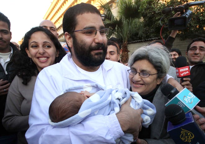 Egyptian prominent blogger Alaa Abdel Fattah, left, hugs his recently born son, Khaled, his mother Laila Soueif, and his sister Ahdaf Soueif, left, after after he was released in Cairo, Egypt, Sunday, Dec. 25, 2011. An Egyptian court ordered the release of Alaa after detained nearly two months ago by the ruling military for his alleged role in deadly sectarian clashes in October. (AP Photo/ Amr Hafez)