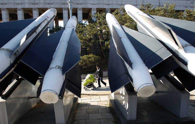 A man and his child pass air missiles at the War Museum, Sunday in Seoul, South Korea.  North Korea on Sunday aired footage showing the uncle and key patron of anointed heir Kim Jong Un wearing a military uniform with a general's insignia, a strong sign he'll play a crucial role in helping the young man take over power and uphold the "military-first" policy initiated by his late father, Kim Jong Il. (AP Photo/Wally Santana)