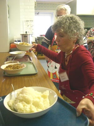 Rena Lukoski arranges bowls of mashed potatoes, stuffing and turkey for volunteers serving more than 100 people gathered for the free Christmas dinner at the Church Hill United Methodist Church in Norwell on Sunday, December 25, 2011.