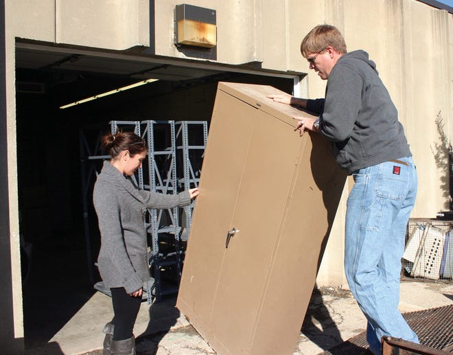 Sara Wright and Heath Steele carry a metal cabinet into the Leavenworth Animal Control shelter on Second Street. They recently were helping Animal Control move back into the facility as members of the Leavenworth-Lansing Leadership Class. The shelter is scheduled to reopen today.