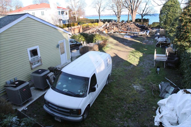 Rubble lies on the ground, Monday, Dec. 26, 2011, in background, after the demolition of a house where a fire left five people dead on Christmas Day, in Stamford, Conn. A commercial construction van also sits parked, foreground, behind the rubble. (AP Photo/Tina Fineberg)