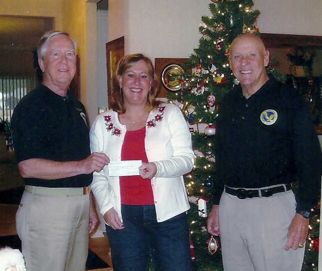 Courtesy Sun City Veterans Association Sun City Veterans Association Commander Larry Bonner, left, presents $2,000 to Janice Palmer of the Marine Corps Officers Wives Club at Parris Island. Vice Commander Bill Fitzgerald, right, arranged for the donation for Marine families in financial need. Each year SCVA raises funds to support active duty military, to pay for postage on packages of comfort items shipped to deployed troops, donations to Wounded Warriors Fund, the Independence Fund and other local community organizations. At a recent membership meeting, Bonner gave a check to an army chaplain to be used to support families in need at Hunter Army Airfield and Fort Stewart, Ga.