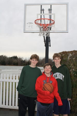 Duxbury High School students Drew Caliendo, left, and brother Ben Caliendo, right, play basketball with kids with disabilities every Sunday as part of the Hoop Heroes program. The Caliendo brothers posed with Hoop Heroes participant Matt Casey, center, in this Dec. 28, 2011 photo.