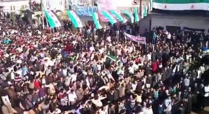 In this image from amateur video made available by the Ugarit News group and shot on Friday, Dec. 30, 2011, protesters gather at an anti-Bashar Assad rally in Hama, Syria. Hundreds of thousands of Syrians poured into the streets across the nation Friday in the largest protests in months, shouting for the downfall of the regime in a defiant display invigorated by the presence of Arab observers, activists said. Despite the presence of the monitors, activists said Syrian forces killed dozens, most of them shot during anti-government protests.