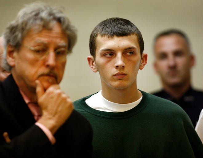 Surrounded by security, and his lawyer at his side,Donald Rudolph, 18, stands in Quincy District Court facing three counts of murder on Monday Nov. 14, 2011. He is charged with the stabbing deaths of his mother, her boyfriend and his sister on Thursday at the family's Weymouth home. His lawyer at left is John Darrell.