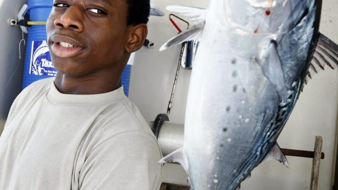 File photo: Denzel Gadsden, 16, a member of the Lantana Junior Police Academy, eyes a Bonito fish he just caught on the Lady K deep sea fishing boat during the Palm Beach County Fishing Foundation's 23rd Annual Kids Fishing Day program.