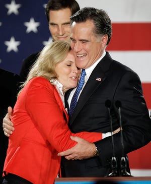 GOP presidential candidate Mitt Romney hugs his wife, Anna, during a rally Tuesday night in Des Moines, Iowa, after winning the GOP caucuses by a mere eight votes.