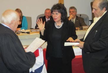 Photo by Lyndsay Cayetana Bouchal/New Jersey Herald Mayor Sylvia Petillo, center, takes the oath of office as administered by Judge Fred Webber, left, at Hopatcong’s reorganization meeting Wednesday. Petillo’s husband, Ron, holds the Bible.