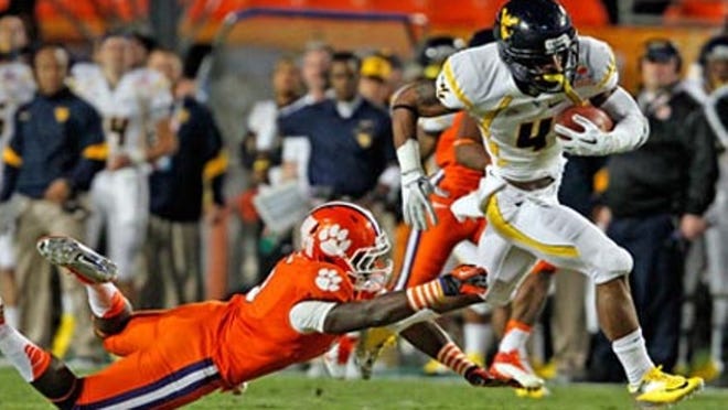 West Virginia Mountaineers receiver Devon Brown moves the ball down field as Clemson Tigers' Jonathan Meeks misses the tackle in the first quarter of the Orange Bowl at Sun Life Stadium in Miami Gardens, Florida, on Wednesday, January 4, 2012.