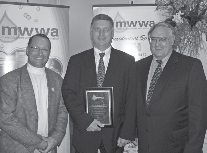Patrick LaPointe, Leominster DPW Director (center) and Roger Brooks, Business Manager (right) accept the Community Award from MWWA President Scott Fitzgerald.