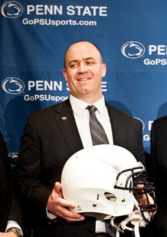 Penn State's new football coach Bill O'Brien holds a Penn State football helmet after he was introduced during a news conference Saturday in State College, Pa.