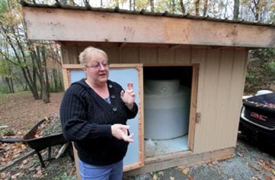 Julie Sautner stands next to a shed containing water adjacent to
her Dimock Township home in October that her family uses for
showers and cleaning purposes. She said her family will not drink
the water. Last week, township residents' water deliveries were
stopped by Cabot Oil and Gas Corp., the company the state deemed
responsible for contaminating township wells with methane.