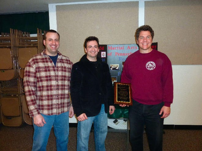 From left, lifelong friend Robert Milne and Howard Latting, both sixth-degree black belts, present the tae kwon do Lifetime Achievement Award to Rocco Lombardo.