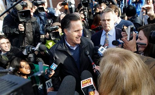 AP Photo/Charles Dharapak - Republican presidential candidate, former Massachusetts Gov. Mitt Romney, is surrounded by reporters as he campaigns on primary election day outside of a polling station at Webster School in Manchester, N.H., Tuesday.