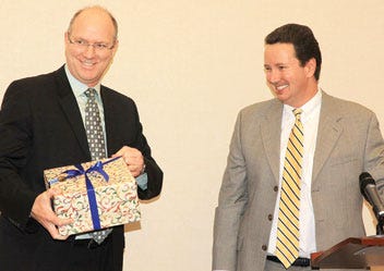 Methodist Medical Center of Oak Ridge's Mike Belbeck, right, who was representing the Oak Ridge Chamber of Commerce during Thursday's reception for recently retired NNSA Y-12 manager Ted Sherry, left, shares some kind words -- and a gift -- with Sherry.