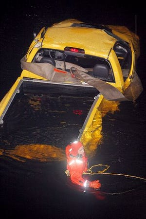 EJ Hersom/Staff photographer 
Dover firefighter Jim Anagnos readies a truck for towing after the vehicle landed in the Cocheco River following an accident along the Spaulding Turnpike Tuesday night in Dover.