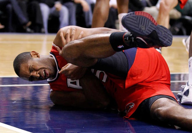 Atlanta Hawks center Al Horford grimaces in pain after he was injured in the first half of an NBA basketball game against the Indiana Pacers in Indianapolis, Wednesday, Jan. 11, 2012. (AP Photo/Michael Conroy)