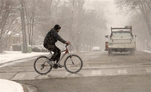 Roads remained clear enough for cyclists along Campbell Street
in Arlington Heights, Ill., during the late-arriving first snow
storm of the season Thursday. (AP Photo/Daily Herald, Bill
Zars)