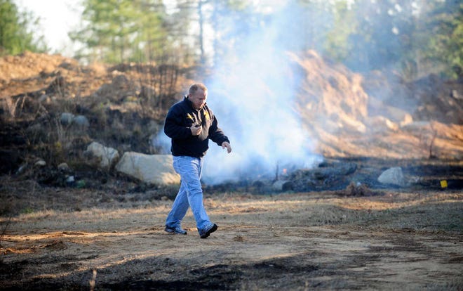 Battalion Chief Brent Willis walks away from a fire scene off Columbia Road near William Few Parkway. The smoke from the fire closed Columbia Road for several hours Saturday.