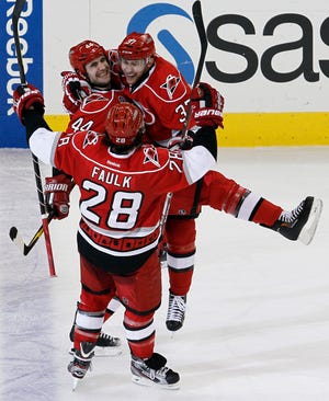 The Hurricanes' Jay Harrison, center, celebrates with Justin Faulk and Tim Brent following Harrison's game-winning goal against the Bruins during the third period of Saturday night's game in Raleigh.