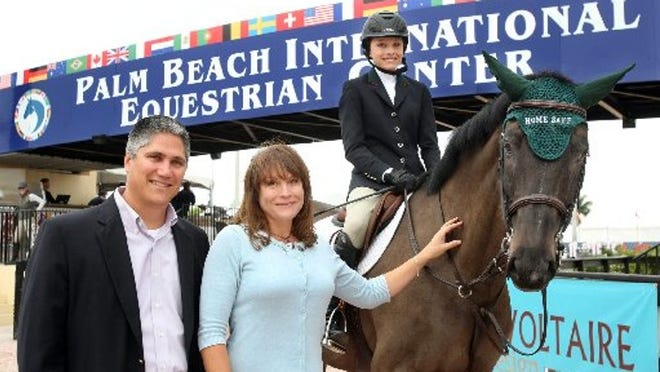 Matt Ladika (from left), CEO of HomeSafe, Cherie Copenhaver, president of the board of HomeSafe, and Cherie's daughter Hannah Patten, 14, with horse Mephisto, owned by Monty Kelly of Stepping Stone Farm, at opening day competition of the FTI Consulting Winter Equestrian Festival at the Palm Beach International Equestrian Center in Wellington Wednesday Jan. 11, 2012.