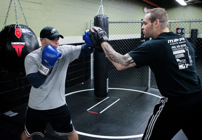 Bill Fraser / Staff Photographer 
 Mixed martial arts fighter Erik Purcell (right) trains Chuckie
Connor of Falls Township (left) with a pair of focus mitts on
Thursday morning. Purcell recently opened a martial arts/fitness
facility in Fairless Hills called MPR Endurance. Purcell started
the gym as a result of training kids who were being bullied.