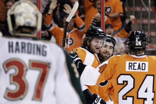 The Flyers' Sean Couturier (center) celebrates with teammates
Marc-Andre Bourdon (second from right) and Matt Read after
Couturier's goal against Minnesota Wild's Josh Harding in the
second period Tuesday.
