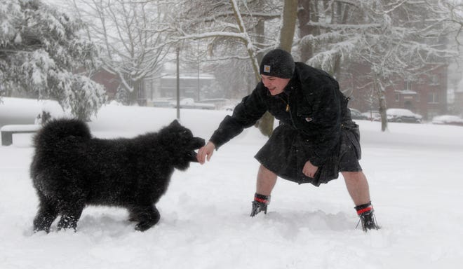 Charles Hetrick wears a kilt as he plays with "Zeus," his Chow-German Shepherd mix in the snow, Wednesday, Jan. 18, 2012, in Tacoma, Wash. Hetrick says he has worn kilts for last six years and didn't think twice about going with bare legs Wednesday despite the cold. A winter storm was expected to bring heavy snow to much of Western Washington throughout the day. (AP Photo/Ted S. Warren)