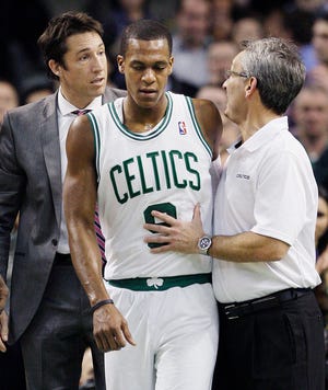 Boston Celtics point guard Rajon Rondo (9) walks off the court with help from a team trainer after he was injured in the second half of an NBA basketball game against the Toronto Raptors in Boston, Wednesday, Jan. 18, 2012. The Celtics won 96-73. (AP Photo/Elise Amendola)
