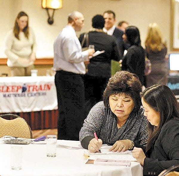Mei Chou, left, a sales director with Mary Kay Cosmetics, interviews Liza Cruz, right, at a Career Fair event in San Francisco on Wednesday. The economy is on an upswing, thanks in part to a four-year low in unemployment benefit applications.