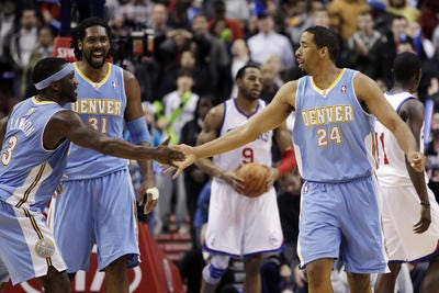 Denver Nuggets' Andre Miller (24) celebrates with Ty Lawson (3)
and Nene (31), of Brazil, after Miller scored a basket in the final
seconds of the second half of an NBA basketball game, Wednesday,
Jan. 18, 2012, in Philadelphia. Denver won 108-104 in overtime. (AP
Photo/Matt Slocum)