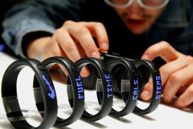 Nike's newest product, the Nike Plus FuelBand, is displayed during a product release announcement on Thursday, Jan. 19, 2012 in New York. The wristband provides an athletic measurement of daily physical movement in time, calories and steps that integrates with the iphone and social media networks for sharing. (AP Photo/Bebeto Matthews)